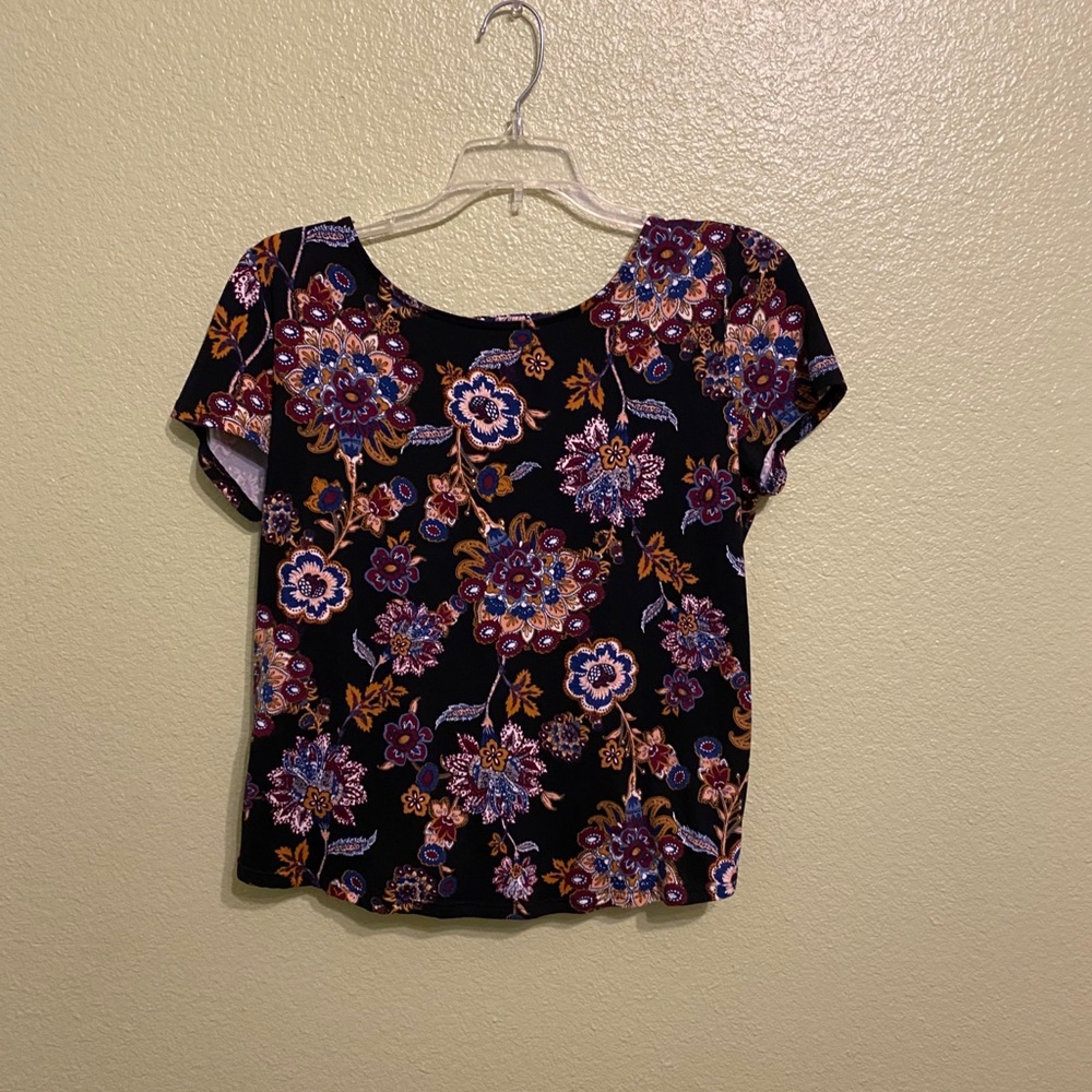 Black floral blouse with backless strappy details.